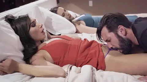 Husband licking young babe's pussy next to sleeping wife